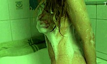 Seorang wanita ramping telanjang dan menikmati dirinya sendiri di kamar mandi